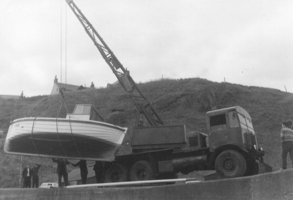 The crane slowly moving the boat out over the harbour