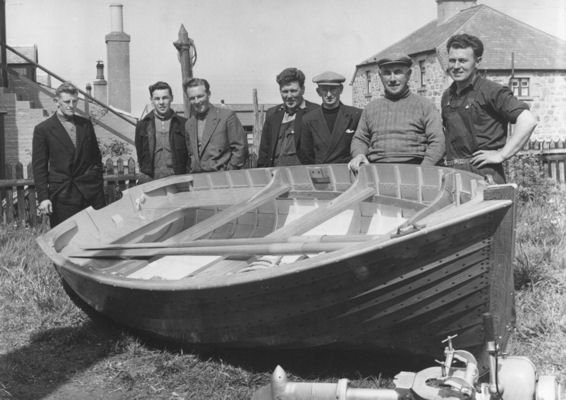 William shows off the dinghy to visitors in the back yard of 28 Seafield Street